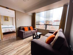 - un salon avec deux canapés et une grande fenêtre dans l'établissement Hotel Rituales Inn - terminal terrestre, à Cusco