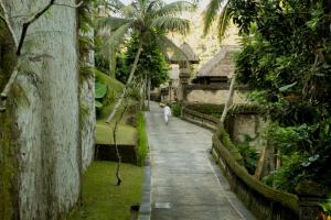 eine Person, die einen Pfad in einem Garten entlang geht in der Unterkunft Puri Wulandari A Boutique Resort & Spa - CHSE Certified in Ubud