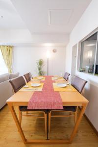 Un comedor con mesa y sillas de madera. en AMS TOWER 1106, en Sapporo