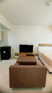 ein Schlafzimmer mit einem Bett und einem TV auf einem Tisch in der Unterkunft Mabolo Taft East Gate in Cebu City