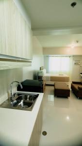 eine Küche mit einem Waschbecken und ein Wohnzimmer in der Unterkunft Mabolo Taft East Gate in Cebu City