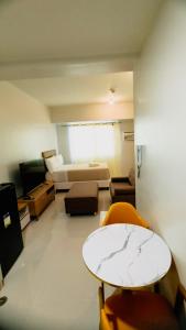 Zimmer mit einem Bett, einem Tisch und Stühlen in der Unterkunft Mabolo Taft East Gate in Cebu City