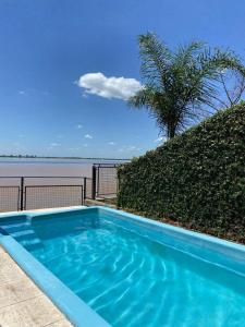 una piscina azul con vistas al agua en CASA JUNTO AL RIO en Paraná