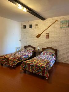 2 camas en una habitación con una pared de ladrillo en CASA JUNTO AL RIO en Paraná