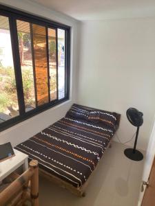 1 cama en una habitación con ventana en MoRue's Den, en Mabini