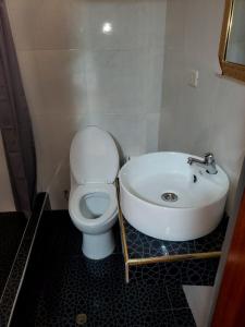 y baño con aseo blanco y lavamanos. en HOTEL EL TREBOL, en Yurimaguas