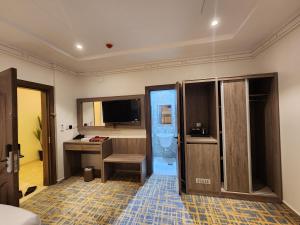 a room with a bathroom with a desk and a television at فندق كنف - kanaf hotel in Ash Sharāʼi‘
