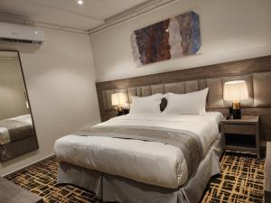 Habitación de hotel con cama grande y espejo en فندق كنف - kanaf hotel en Ash Sharāʼi‘
