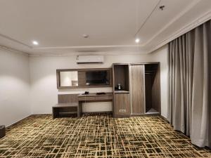um quarto com uma televisão de ecrã plano na parede em فندق كنف - kanaf hotel em Ash Sharāʼi‘