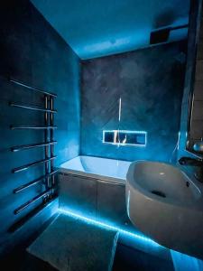 a bathroom with a sink and a tub with blue lights at Luxury Apartment London in London