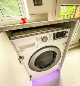 a washing machine in a cabinet in a kitchen at Luxury Apartment London in London