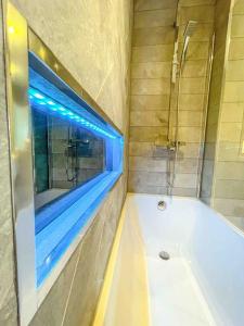ein Bad mit einer Badewanne und einem Fenster in der Unterkunft Luxury Apartment London in London