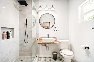 a bathroom with a shower and a toilet and a mirror at Spacious & Comfortable House Minutes To Center in Oklahoma City