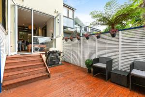 een patio met een houten bank en een hek bij Elegant 1-Bed with Study by Balmain Wharf in Sydney