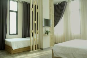 a bedroom with two beds and a flat screen tv at Khách sạn Phước Lộc Thọ 2 - 福禄寿 in Ho Chi Minh City