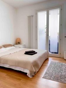 een witte slaapkamer met een bed en een tapijt bij Luxury Apartment Centre. Pool. Beach and Shopping in Lido di Jesolo