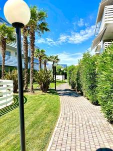 ein Straßenlicht neben einem Bürgersteig mit Palmen in der Unterkunft Luxury Apartment Centre. Pool. Beach and Shopping in Lido di Jesolo