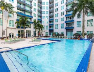 a swimming pool with palm trees in front of a building at Luxury- 2BR in Channel Side - downtown Tampa in Tampa