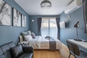 ein blaues Zimmer mit einem Bett und einer Couch in der Unterkunft Felice Nishi-Shinjuku in Tokio