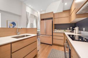 a kitchen with wooden cabinets and a stainless steel refrigerator at The Nomad Saint Jacques in Montréal