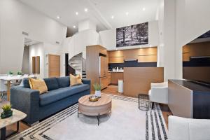 a living room with a blue couch and a table at The Nomad Saint Jacques in Montréal