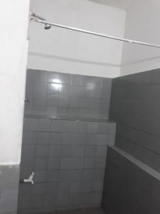 a bathroom with a white tiled shower with at Drop Hostel in Kandy