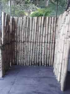a fence made of bamboo standing next to a sidewalk at Drop Hostel in Kandy
