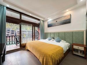 a bedroom with a bed and a view of the ocean at Fenghuang Ancient Town Lazy Cat Riverside Inn in Fenghuang