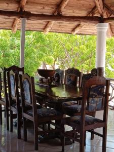 een houten tafel en stoelen op een veranda bij Mkuu House in Malindi