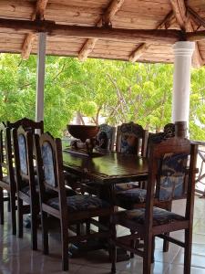 a wooden table and chairs on a porch at Mkuu House in Malindi