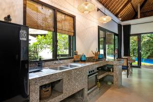 - une cuisine avec évier et quelques fenêtres dans l'établissement Villa Ayung, à anur