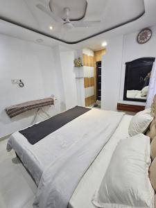 a large white bed in a room with a tv at Stylish Penthouse Apartment - ATITHI ESTATE in Hyderabad