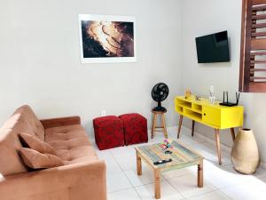 a living room with a couch and a yellow table at Casa Centro de Jijoca in Jijoca de Jericoacoara