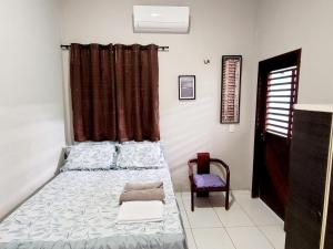 um quarto com uma cama e uma cadeira em Casa Centro de Jijoca em Jiloca de Jericoacoara