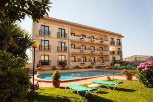 a large building with a swimming pool in front of it at Hotel Oca Vermar in Aios