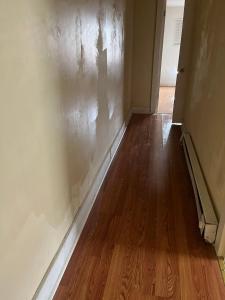 an empty room with a wall and wood floors at A bedroom with a shared full bathroom in Philadelphia
