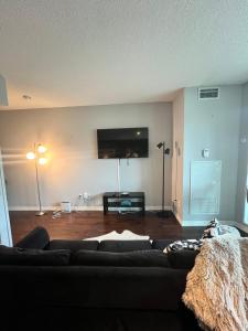 a living room with a couch and a flat screen tv at Downtown Toronto Cozy Suite in Toronto