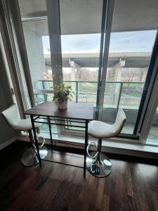 a table and two chairs in front of a large window at Downtown Toronto Cozy Suite in Toronto