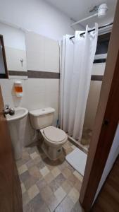 a bathroom with a toilet and a shower curtain at Yellow House in Manizales