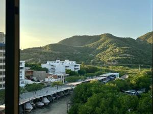 a view of a city with buildings and a mountain at Acogedor apartamento Rodadero Santa Marta con vista al Lago in Santa Marta
