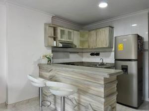a kitchen with a wooden counter and a refrigerator at Acogedor apartamento Rodadero Santa Marta con vista al Lago in Santa Marta