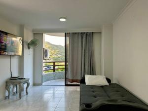 a living room with a couch and a sliding glass door at Acogedor apartamento Rodadero Santa Marta con vista al Lago in Santa Marta