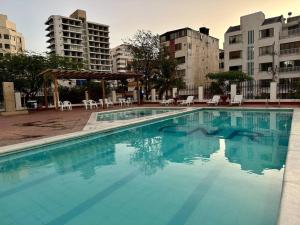 a large swimming pool in a city with buildings at Acogedor apartamento Rodadero Santa Marta con vista al Lago in Santa Marta