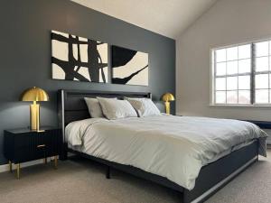 a bedroom with a large bed with white sheets and two lamps at Masters 2026 in your backyard in Augusta