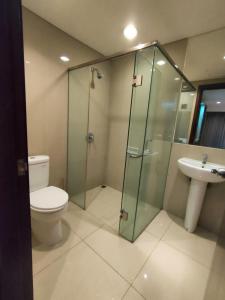 a bathroom with a shower and a toilet and a sink at eL Royale Apartment by Faris Property in Bandung