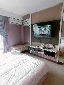 a hotel room with a bed and a flat screen tv at eL Royale Apartment by Faris Property in Bandung +28 photos