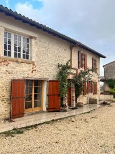 an old brick house with brown doors and windows at La Vieille Tronque in Castelnau-de-Lévis