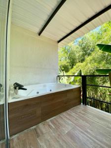 a bath tub in a bathroom with a balcony at ORIGEN FINCA HOTEL in Quimbaya