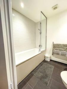 uma casa de banho com uma banheira, um WC e um lavatório. em Central London Apartment + Gym + Pool + Parking em Londres