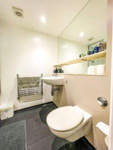 uma casa de banho branca com um WC e um lavatório em Central London Apartment + Gym + Pool + Parking em Londres